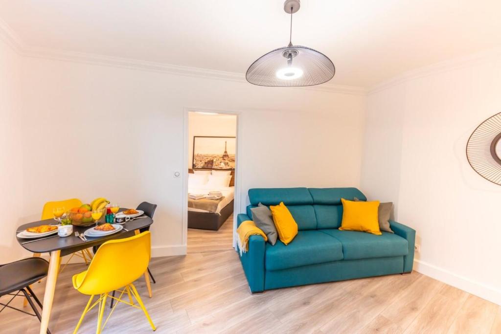 un salon avec un canapé bleu et une table dans l'établissement Charming apartment - 1BR-4P - Bastille, à Paris