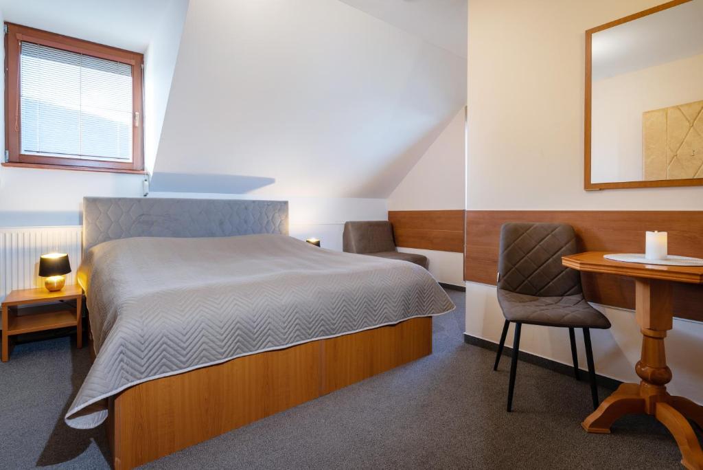 um quarto com uma cama, uma secretária e uma cadeira em Vila Viktória em Rajecké Teplice