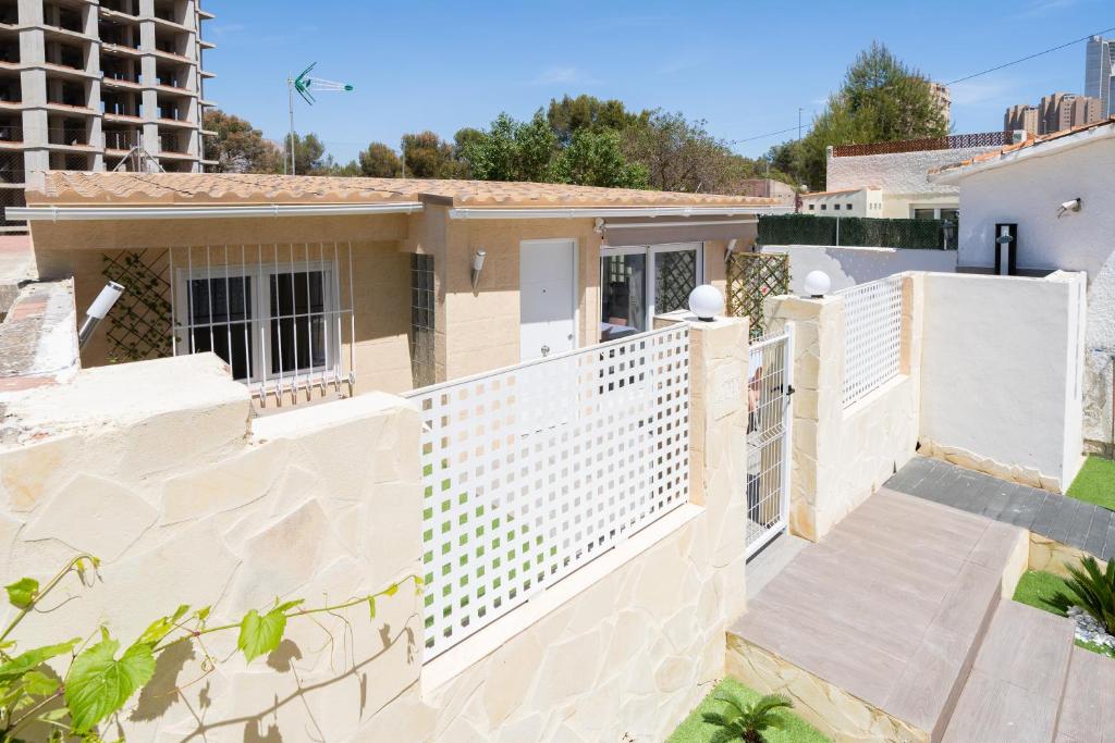 una recinzione bianca di fronte a una casa di Apartamento ALMA con terreno privado y parking compartido - a 800m de Playa Poniente a Benidorm