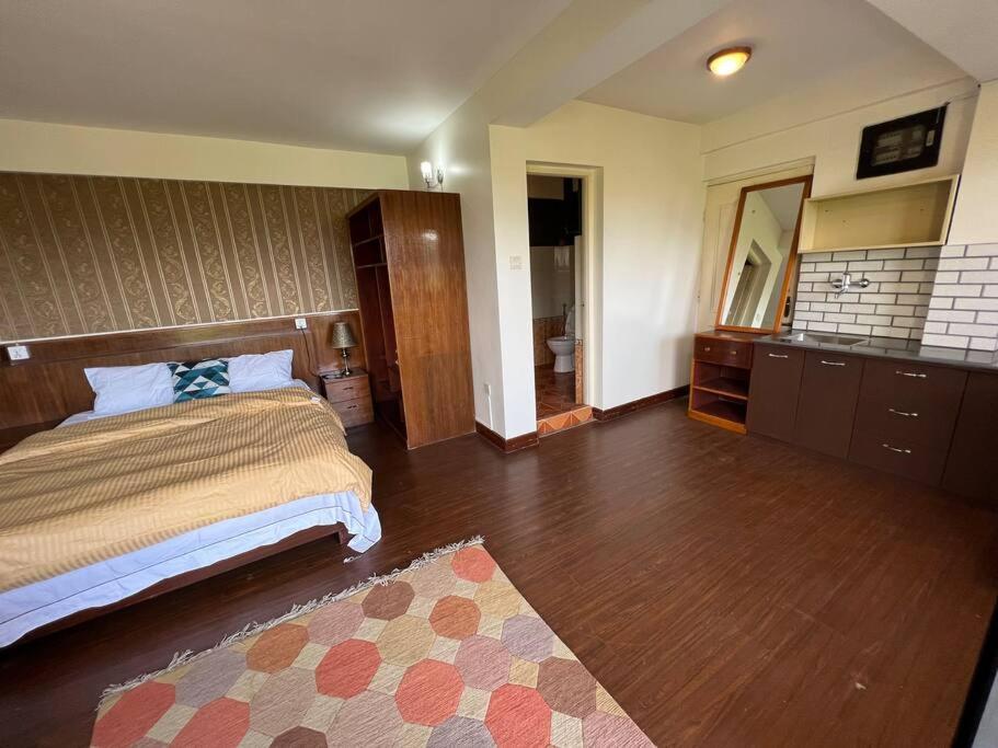 1 dormitorio grande con 1 cama y baño en Avocado Apartments, en Khadkagaon