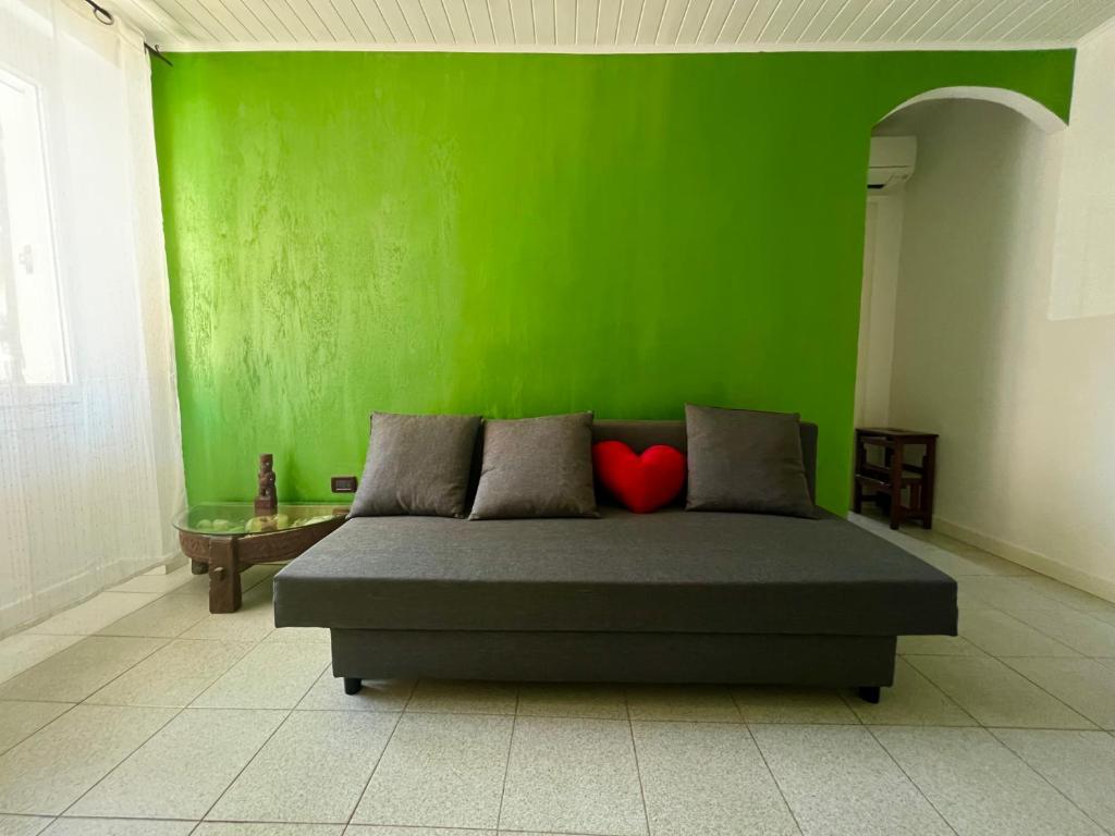 a green wall with a bed in a room at CASA BARBARA in Ventimiglia