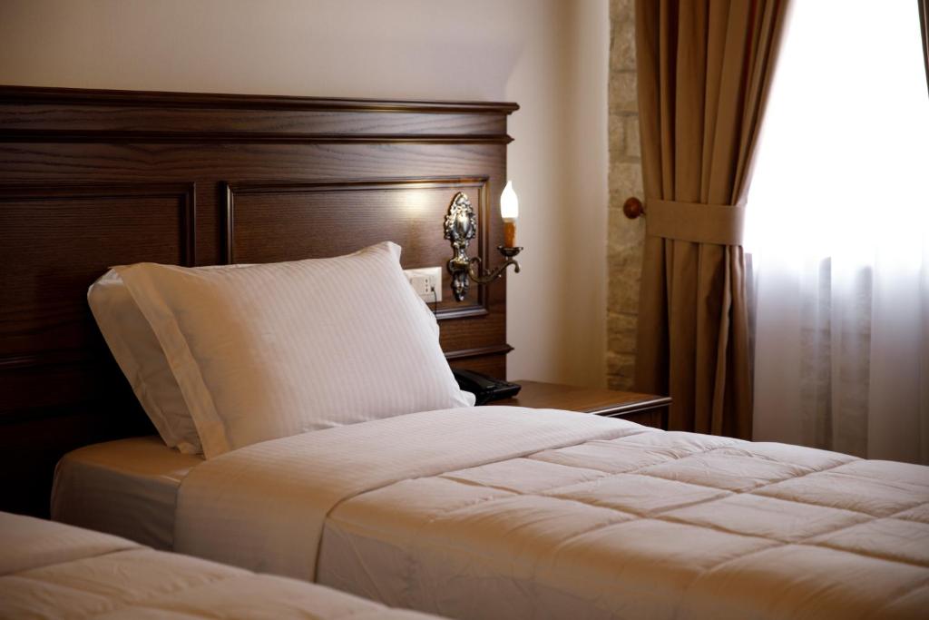 Postel nebo postele na pokoji v ubytování Rose Garden Hotel