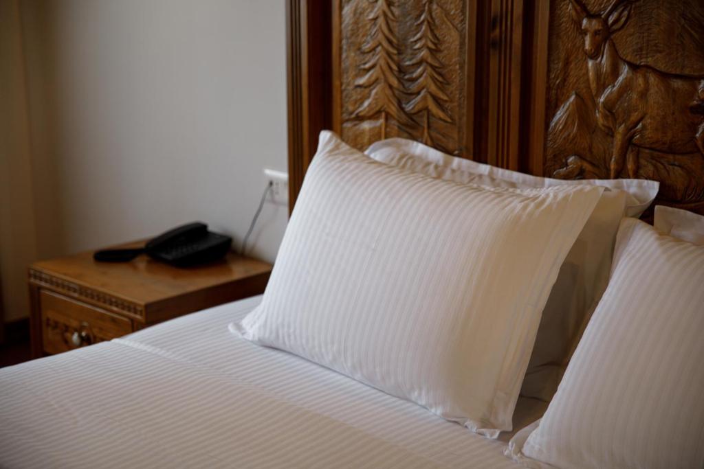 Postel nebo postele na pokoji v ubytování Rose Garden Hotel