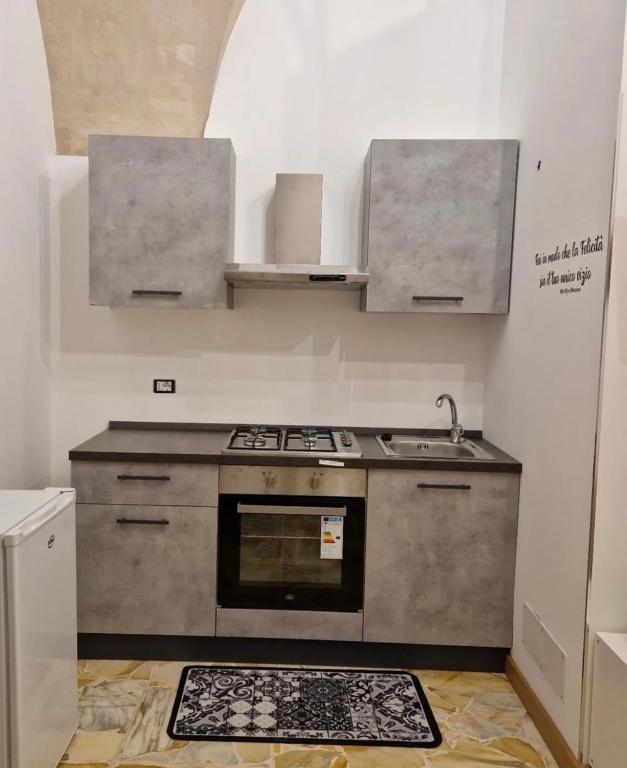 uma cozinha com um fogão e um lavatório em B&B UNICI em Grammichele