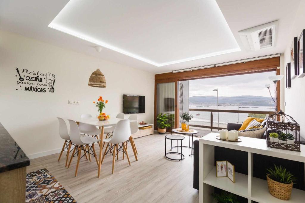 cocina y sala de estar con mesa y sillas en El balcón de Covelo en Pontevedra