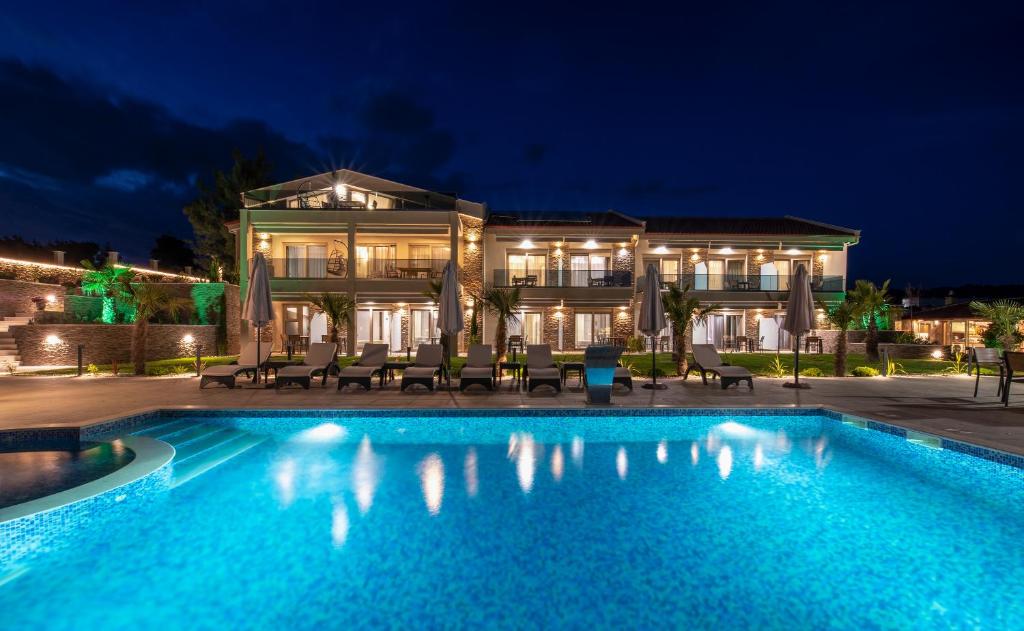 a swimming pool in front of a building at night at Villa Sara in Nikiti