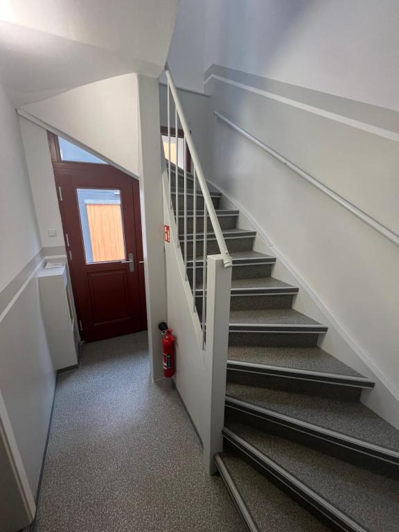 a staircase with a red door and a red fire hydrant at Hafen Appartements Wismar in Wismar