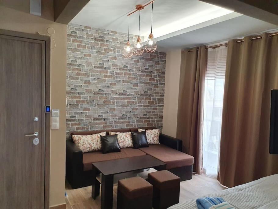 salon z kanapą i ceglaną ścianą w obiekcie Rotonda citycenter two rooms apart.New renovated! w Salonikach
