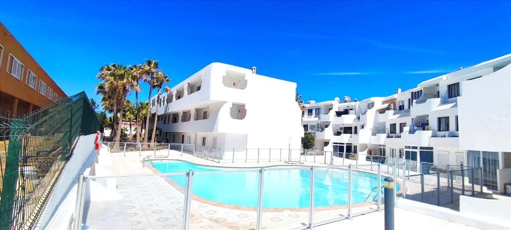 een gebouw met een zwembad naast een gebouw bij Holiday rent Fuerteventura in Costa de Antigua