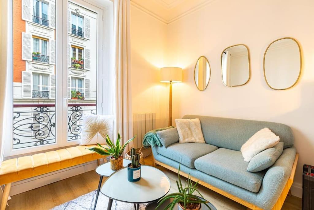 ein Wohnzimmer mit einem Sofa und einem Fenster in der Unterkunft GuestReady - Lovely urban retreat in the 17th Arr. in Paris