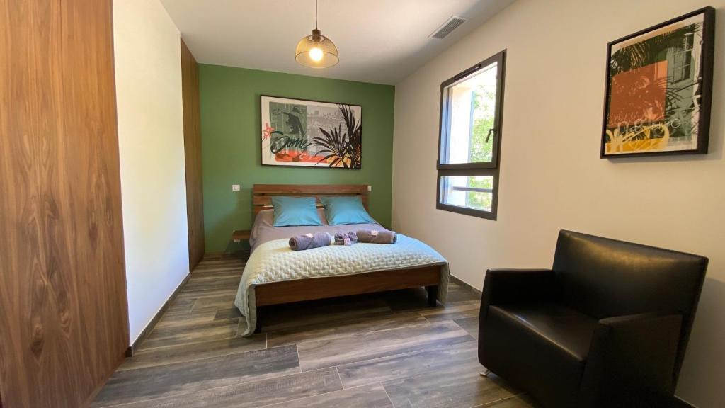 a bedroom with a bed and a chair in it at LES ROCHES DE BAUDISSET in Saint-Paul-en-Forêt