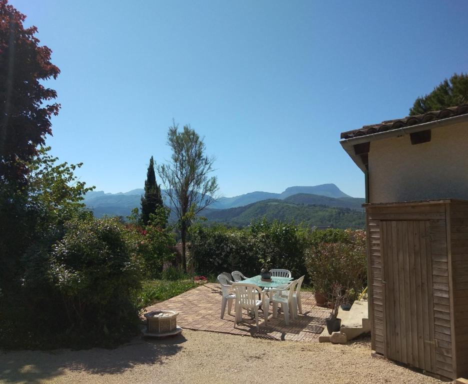 um pátio com uma mesa e cadeiras num quintal em Villa confort, vue d'exeption, montagne, jardin em Crest