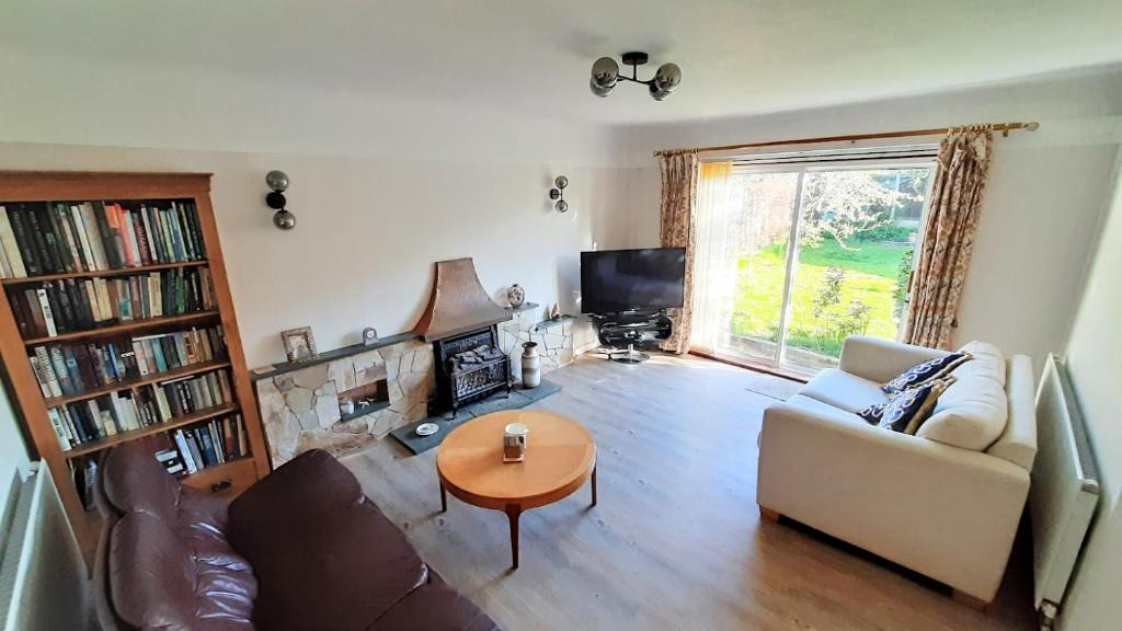 a living room with a couch and a table at GOLF OPEN HOYLAKE Bungalow In West Kirby in West Kirby