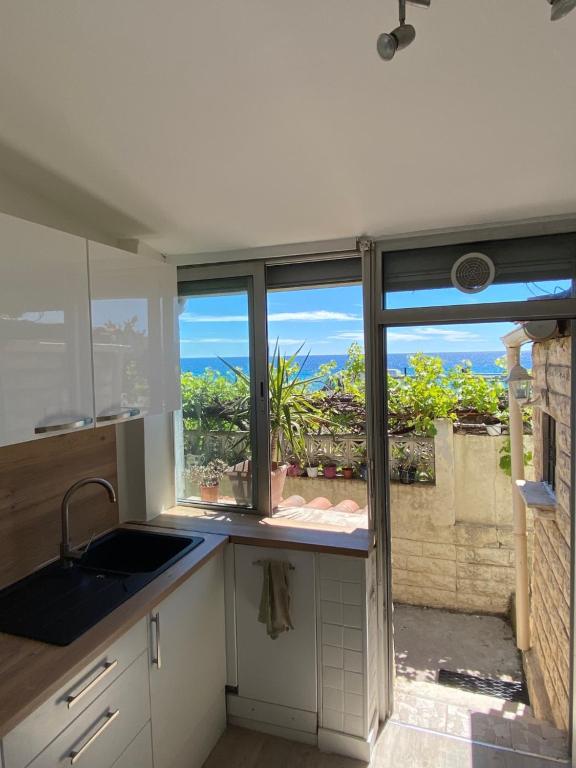 une cuisine avec une fenêtre donnant sur l'océan dans l'établissement CANNES RIVAGE bord de mer, à Cannes