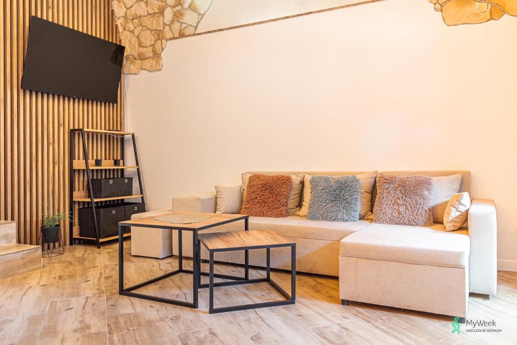 salon z kanapą i dwoma stołami w obiekcie Apartament w Rynku I, MyWeek w mieście Radków