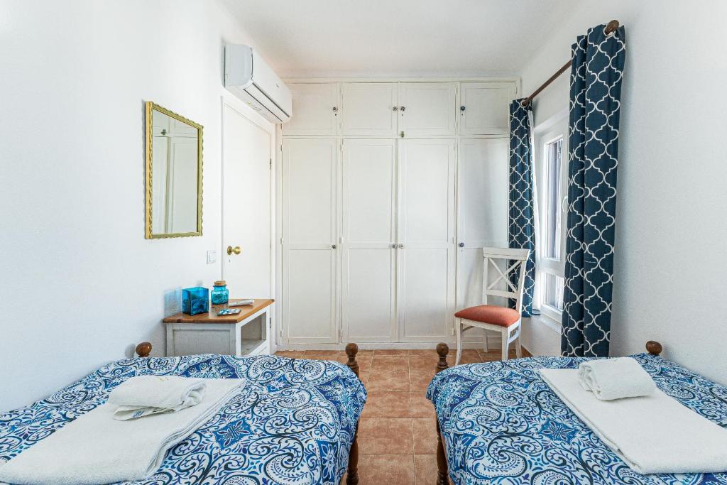 ルースにあるCasa do Coral - Praia da Luzのベッドルーム1室(ベッド2台、鏡付)