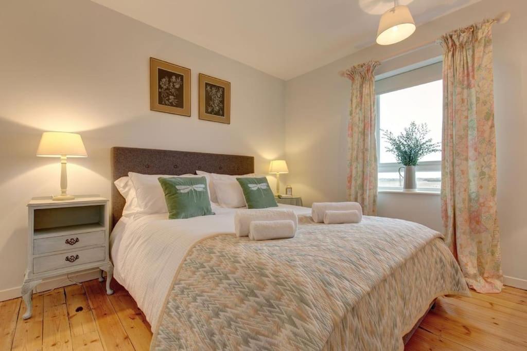 a bedroom with a large bed with a window at No 1 Sparham Hall - Norfolk Cottage Agency in Necton