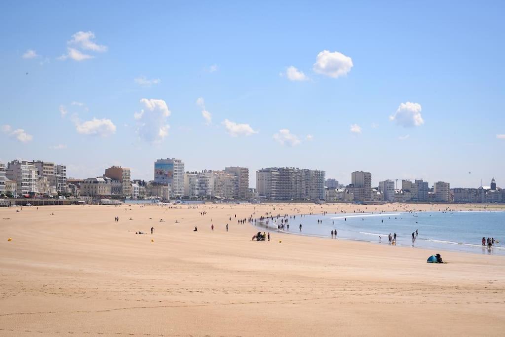 La Maison des sables , 300m de la plage في لي سابلِ دولونْ: مجموعة من الناس على شاطئ مع المحيط