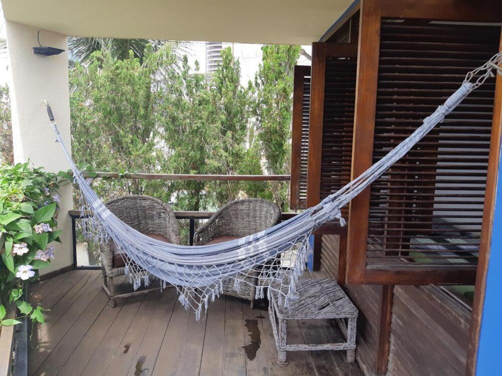 een hangmat op de veranda van een huis bij Happy Paradise Hostel in Natal