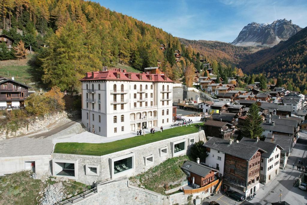 an aerial view of a building in a town with a mountain at Grand Hotel du Cervin - Auberge de jeunesse wellness in Saint-Luc