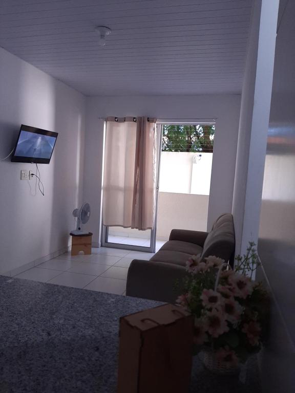 a living room with a couch and a tv at Cantinho arretado da Peste - Apartamento in Aquiraz