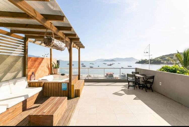 Un patio con mesa y vista al mar. en Villa das Flores - aptos 2 e 9, en Pinheira