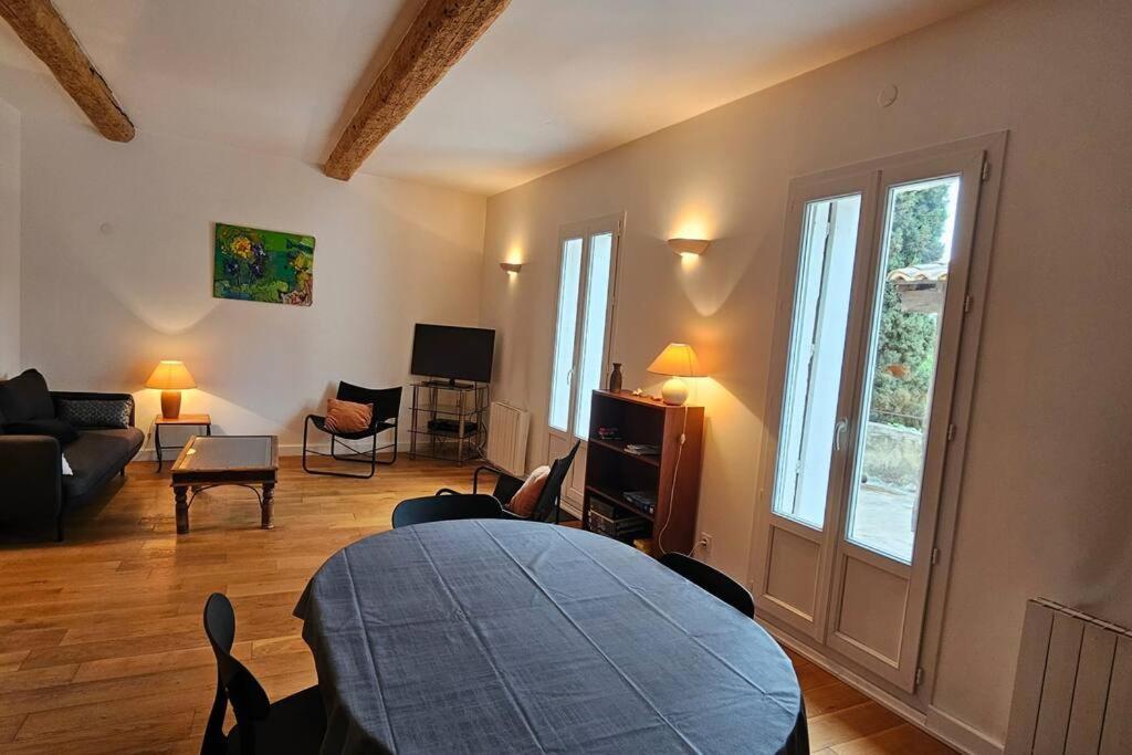 salon z kanapą i stołem w obiekcie Maison vigneronne 8p / jardin / parking w mieście Gigean