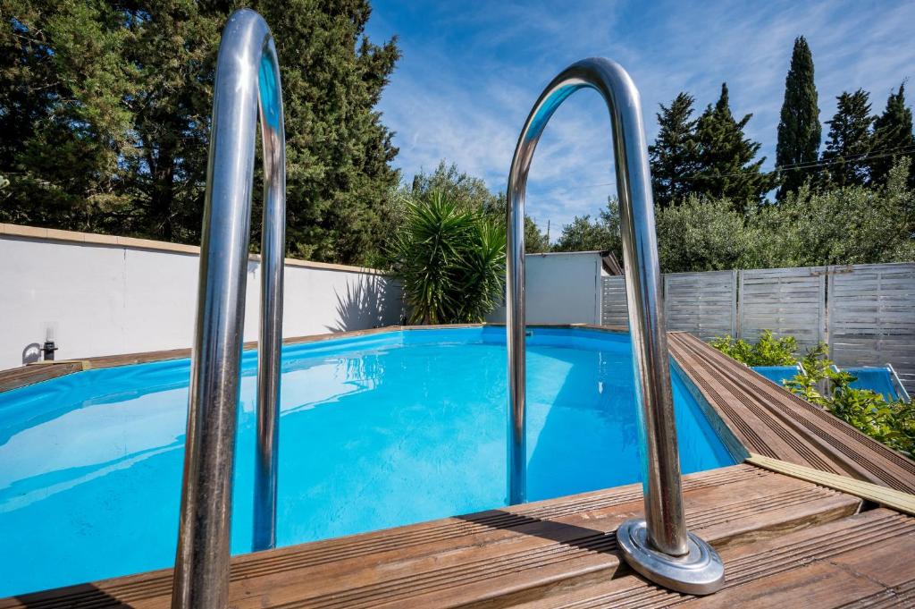 a swimming pool with metal railings next to a wooden deck at Villa Gagliardetta in Castellammare del Golfo