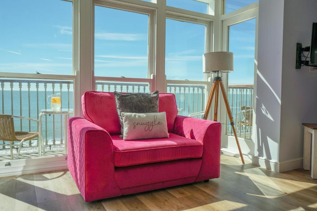 a pink chair with a pillow on a balcony at The Vitamin Sea in Ventnor