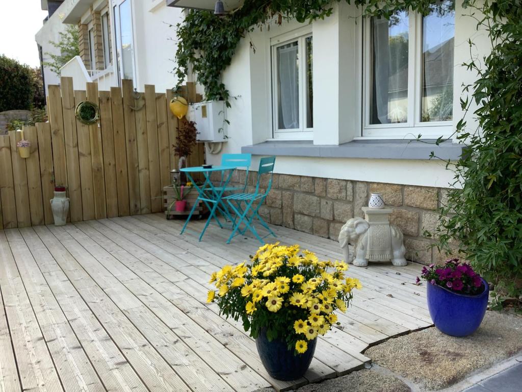 een patio met twee vazen gevuld met gele bloemen bij Les Bruyeres in Concarneau