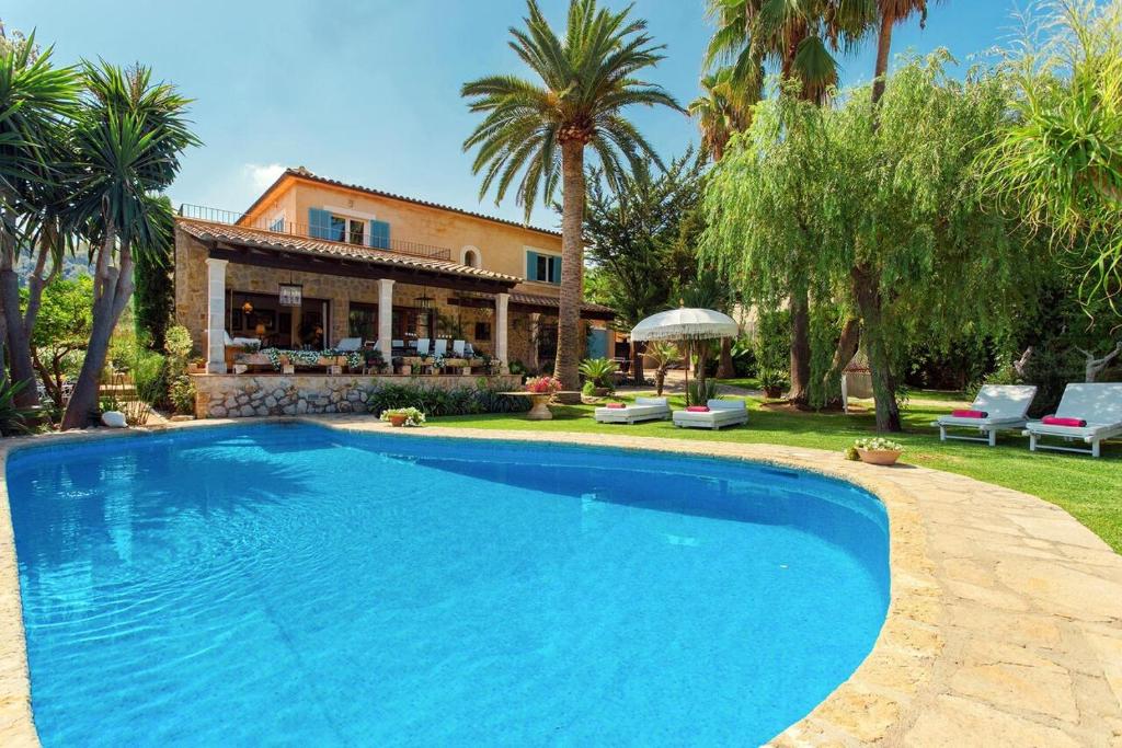 a large blue swimming pool in front of a house at Font in Mancor del Valle