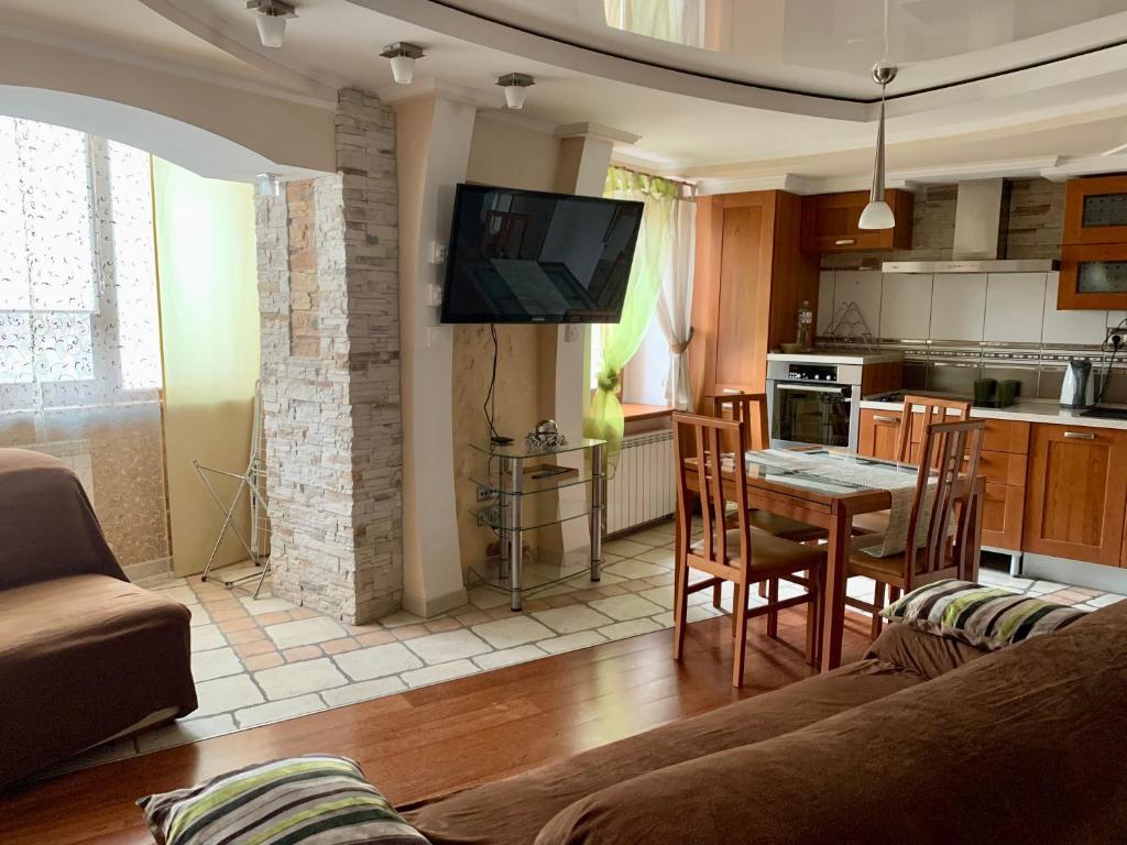 a living room with a couch and a table and a kitchen at Apartaments Teris in Zhytomyr