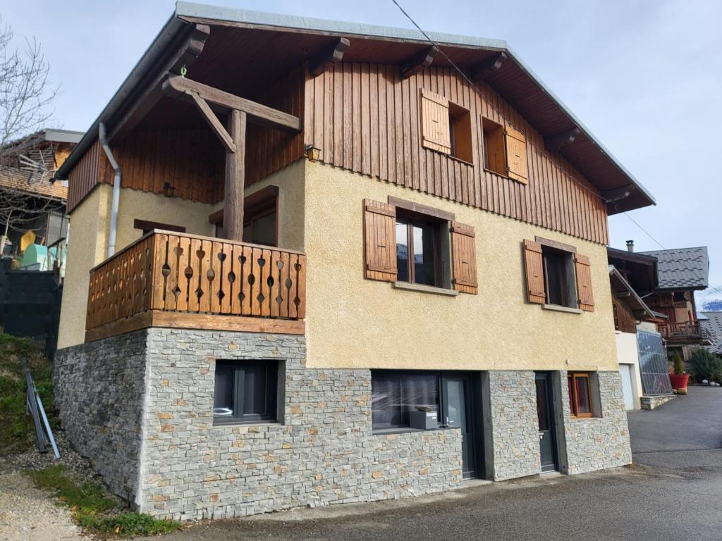 un bâtiment avec un balcon au-dessus dans l'établissement Maison de moyenne montagne baignée par le soleil, à La Côte-dʼAime