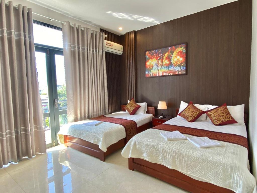 Habitación de hotel con 2 camas y ventana en Hoàng Ngân Hotel Phú Yên, en Liên Trì (3)