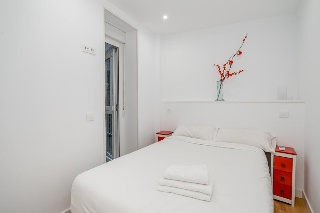 マドリードにあるBuenavistaの白いベッドルーム(白いベッド1台、窓付)