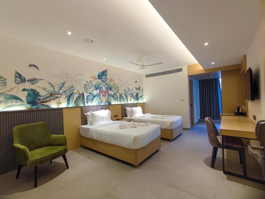 ヴィシャカパトナムにあるSignature Hotelsのベッド2台、テーブルと椅子が備わるホテルルームです。