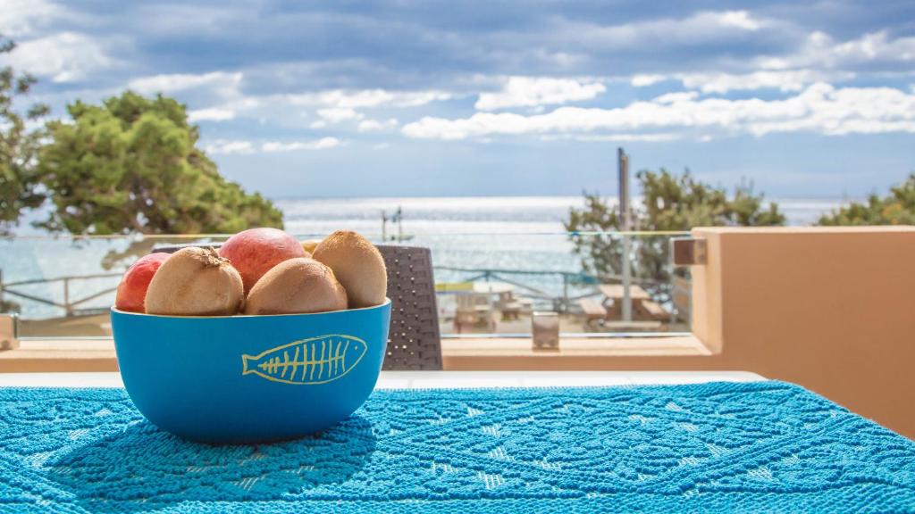 a bowl of fruit on a table with a view of the ocean at Casa Baddò, fronte spiaggia A/C in Cala Gonone