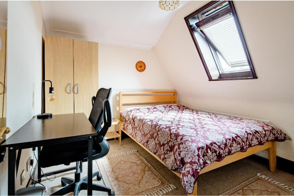 een slaapkamer met een bed, een bureau en een raam bij Double room 2 mins from station in Belvedere