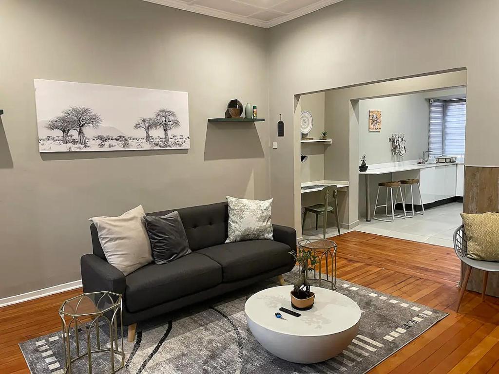 a living room with a black couch and a table at Modern Apartment - 2081 in Bulawayo