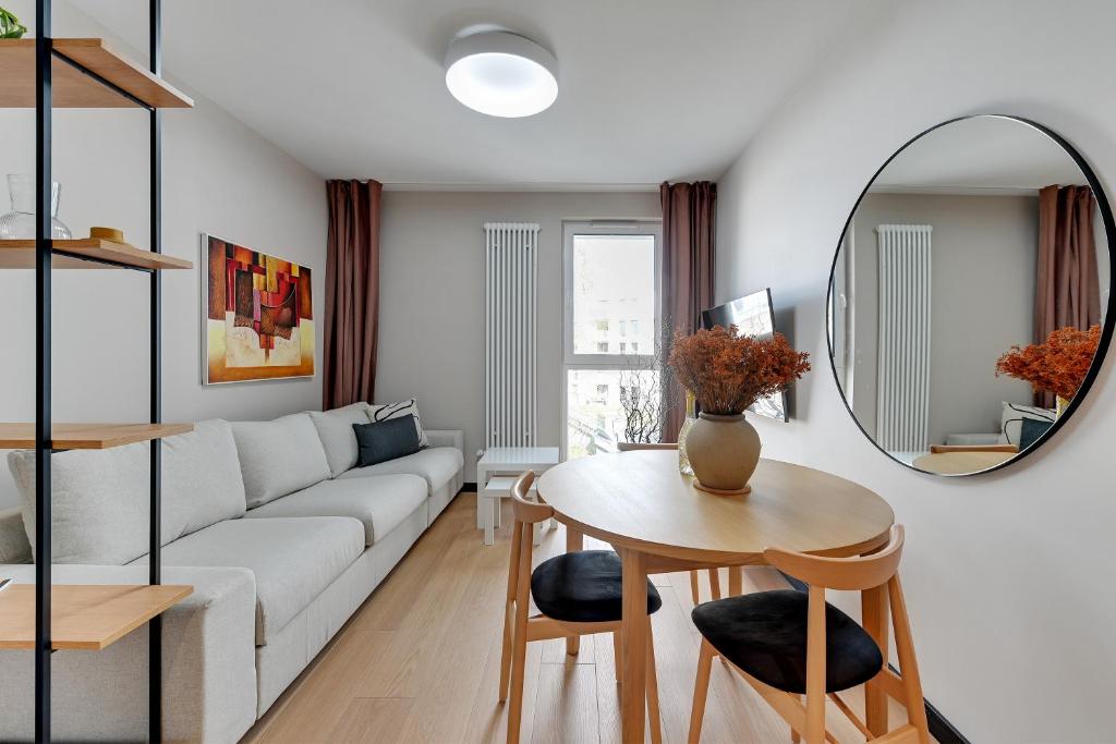 a living room with a couch and a table and a mirror at Boutique Aura 40 by Grand Apartments in Gdańsk