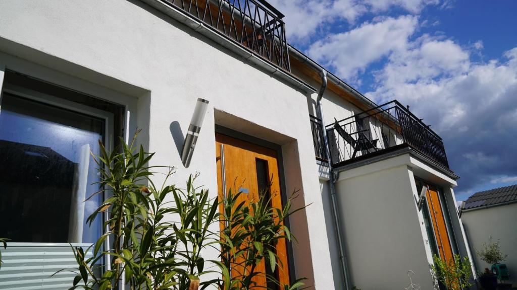 a white house with a yellow door and a balcony at Ferienwohnung Meine Tante in Trittenheim