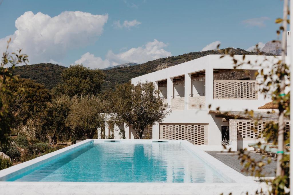 una villa con piscina di fronte a una casa di VILLA FLAKA Boutique Hôtel a Cargèse