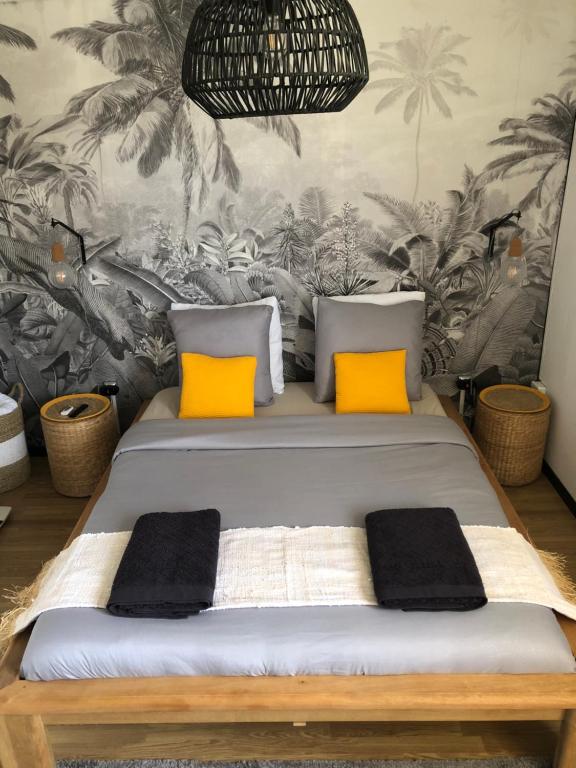 a bedroom with a bed with orange pillows at 2 cap beach in Saint-Pierre