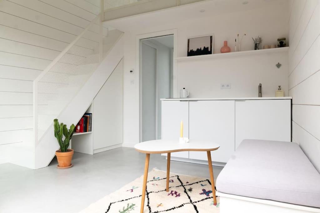 a white room with a table and a chair at Tiny House d'exception au bord de mer in La Bernerie-en-Retz