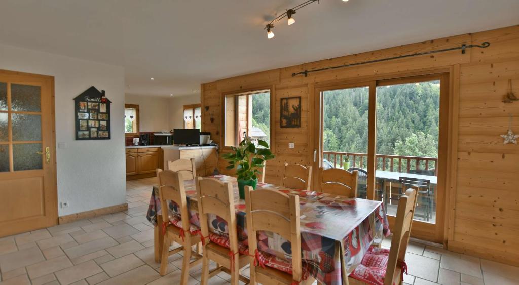 una cucina e una sala da pranzo con tavolo e sedie di La petite Anfiane a Le Grand-Bornand