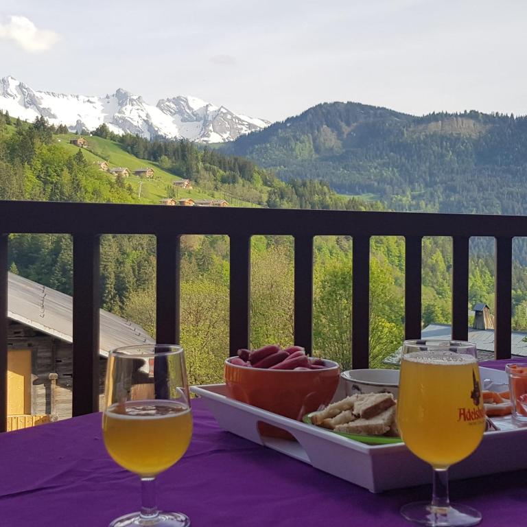 a table with a tray of food and two glasses of wine at La petite Anfiane in Le Grand-Bornand