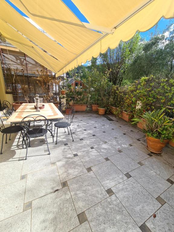 a patio with a table and chairs and an umbrella at Casa di Bianca by PortofinoVacanze in Santa Margherita Ligure