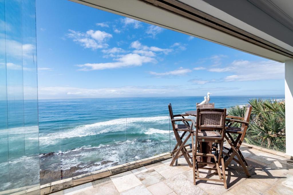 a balcony with two chairs and a view of the ocean at The Islands 13 - Newly renovated with UPS that powers TV, Wifi and 1 light in Ballito