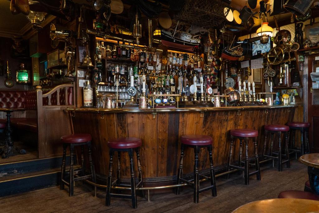 a bar with stools in a pub at The Olde Ship Inn in Seahouses