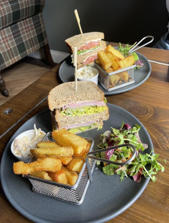 two plates with a sandwich and french fries and salad at The Olde Ship Inn in Seahouses